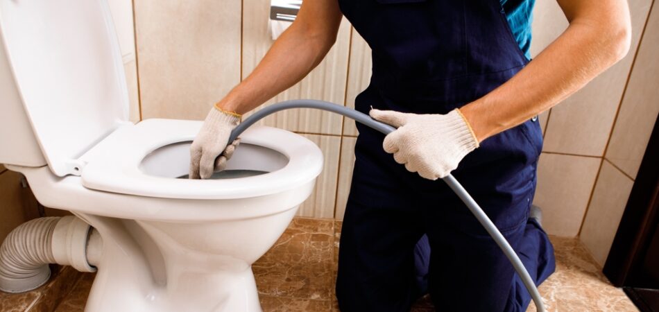 Plumber,unclogging,blocked,toilet,with,hydro,jetting,at,home,bathroom.
