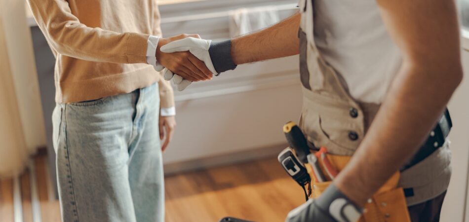 Close,up,of,repairman,in,uniform,shaking,hands,with,woman